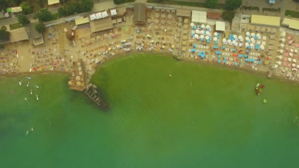 Luchtfoto. Populaire stad beach. Veel parasols aan de kust, 4k — Stockvideo