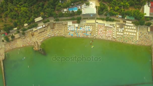 Légifelvételek. Népszerű városi strand. Sok napernyők a tengerparton, 4k — Stock videók