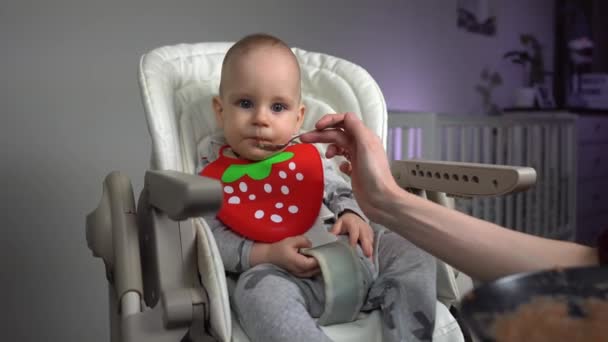 Dolly Shot Mother Feeding Charming Baby Boy Baby Chair — Stock Video
