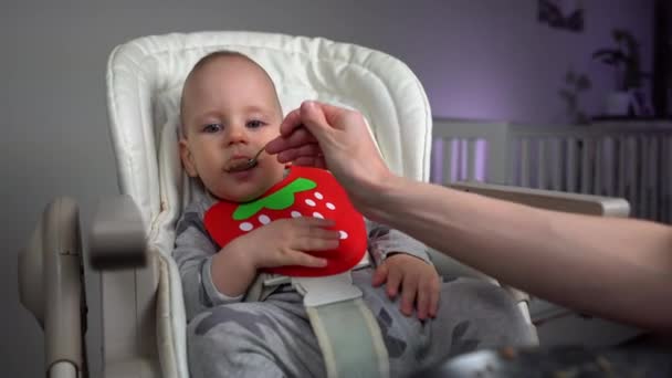 Dolly Shot Mère Nourrissant Charmant Petit Garçon Dans Une Chaise — Video