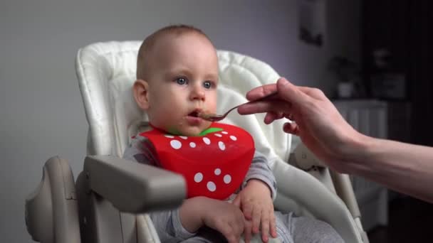 多莉开枪了妈妈在婴儿椅上喂可爱的男婴 — 图库视频影像