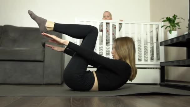 Dolly Shot Young Mother Performs Exercise Home Baby Background — Stock Video