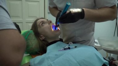 Diş sağlığı kliniğinde kadın hastalarla çalışan dişçi doktorları. 4k