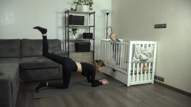 Dolly Shot Young Mother Performs Exercise Home Her Baby — Stock Video