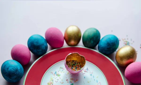 Ovos de páscoa coloridos com confeitaria polvilhando na placa — Fotografia de Stock