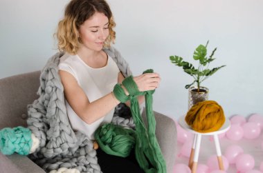 Genç kadın oturuyordu ve Merinos yün ile örme