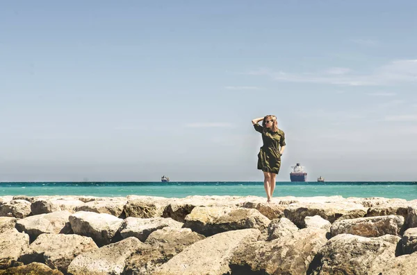 Mooie jonge vrouw staat op de rand van de rotsen en op zoek forw — Stockfoto