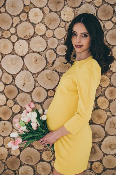 Hermosa embarazada feliz mujer con flores —  Fotos de Stock