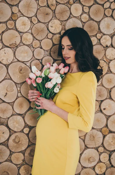 Hermosa embarazada feliz mujer con flores —  Fotos de Stock