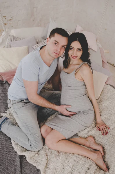 Lycklig familj av gravid kvinna och ung man — Stockfoto