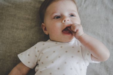 Beyaz arka plan üzerinde yalan onun ağzına el ile güzel küçük bebek 