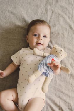 Onu oyuncak sarılma ve kameraya bakıyor güzel küçük bebek 