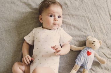  küçük bebek ona oyuncaklar ile yatağa yalan 