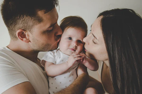 küçük bebek tutan ve üzerinde beyaz adam öpüşme genç anne