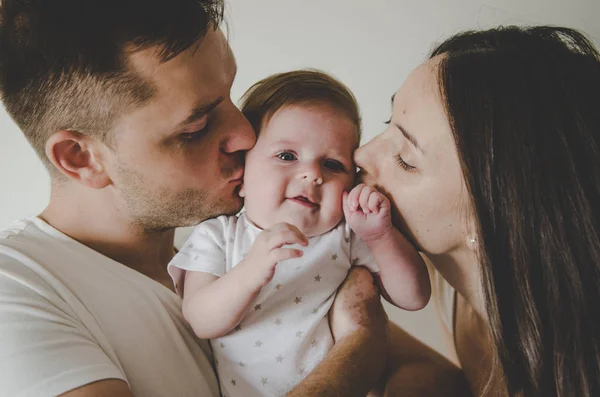 küçük bebek tutan ve üzerinde beyaz adam öpüşme genç anne