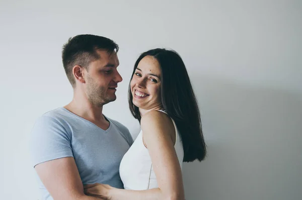 Belo jovem casal abraçando e sorrindo no fundo branco — Fotografia de Stock