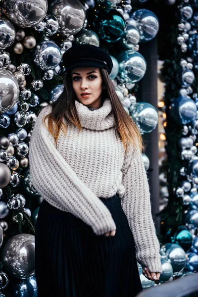 若いです女性で暖かいオーバーサイズセーターポーズクリスマスデコの近く — ストック写真