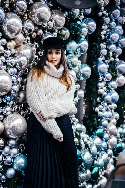 크리스마스 데코 근처에 있는 따뜻 한 크기의 스웨터를 입은 젊은 여성 — 스톡 사진