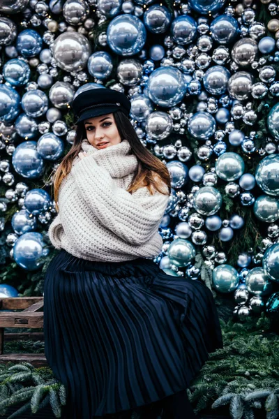 크리스마스 데코 근처에 있는 따뜻 한 크기의 스웨터를 입은 젊은 여성 — 스톡 사진