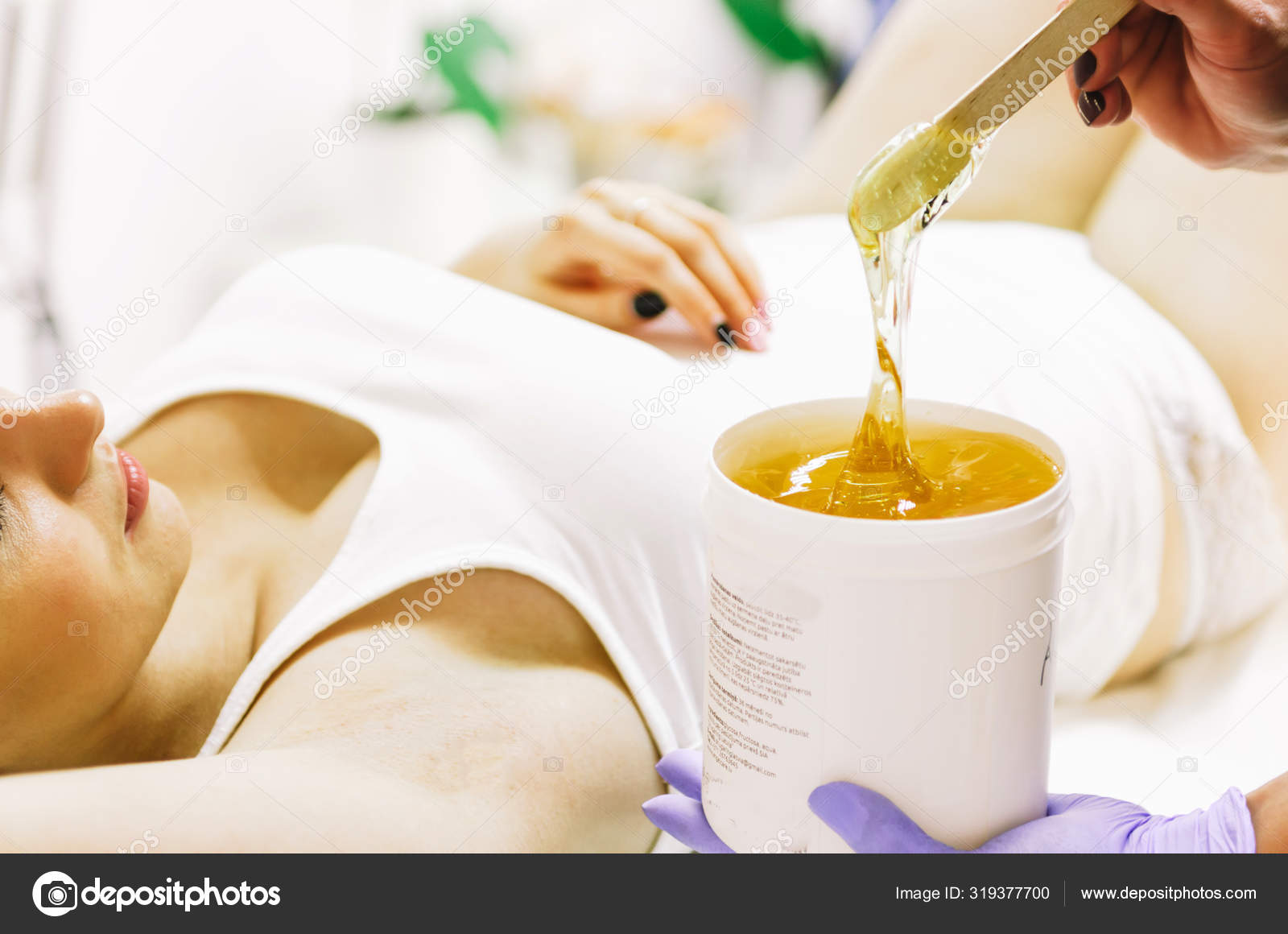 Woman doing hot sugar wax hair removal Stock Photo by ©Marianarbh1 319377700