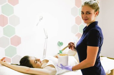 Sıcak şekerli saç kesimi yapan bir kadın. 