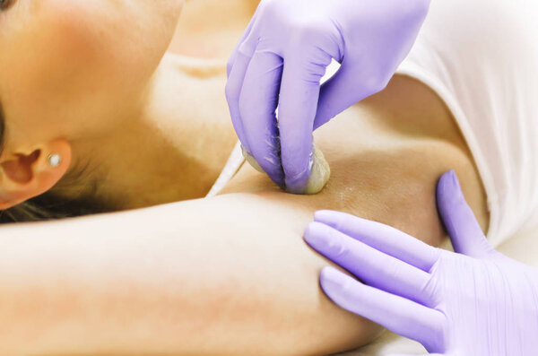 woman doing hot sugar wax hair removal 