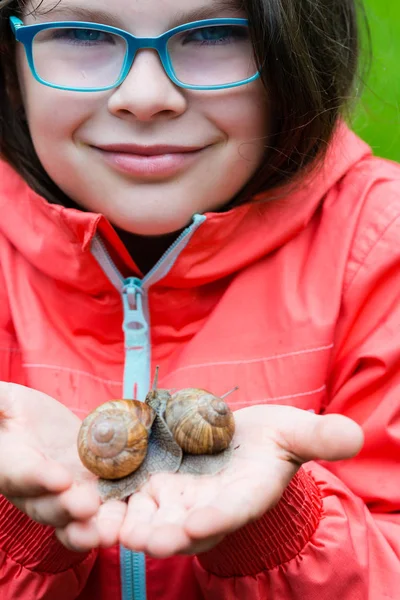 Lächelndes kleines Mädchen mit Gartenschnecken — Stockfoto