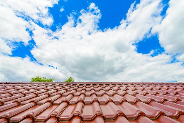 Nueva azotea roja contra el cielo azul nublado — Foto de Stock