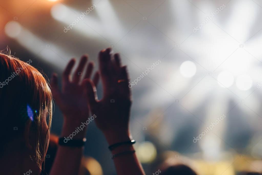 Girl raising her hands and enjoying a great concert