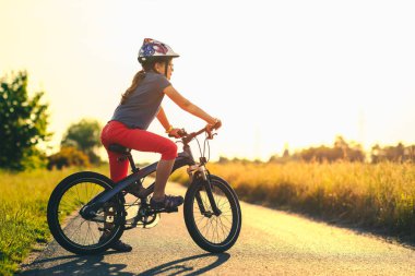 Gün batımında bisikletle aktif genç kız