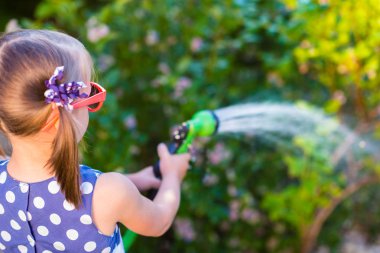 Küçük mutlu kız sulama Bahçe