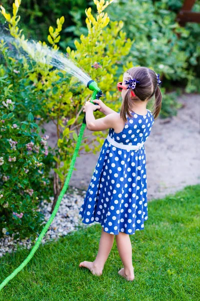 Gadis kecil bahagia, mengairi kebun. — Stok Foto