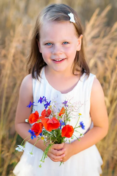 Petite fille mignonne avec des fleurs sauvages bouquet de pavot rouge dans le summ — Photo