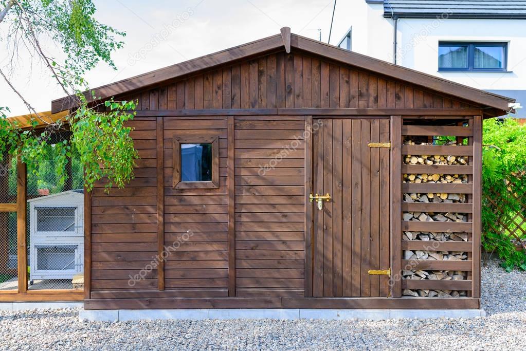 Garden shed exterior in Spring, with woodshed