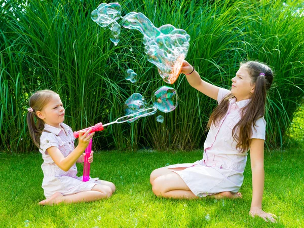 Niños jugando con jabón varita de burbujas en el parque — Foto de Stock