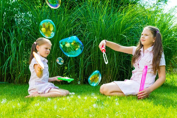 Niños jugando con jabón varita de burbujas en el parque — Foto de Stock