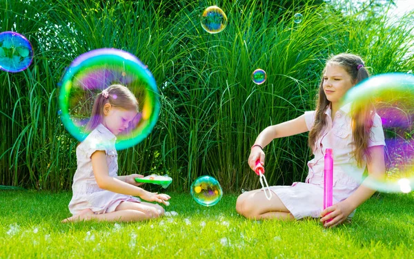 Niños jugando con jabón varita de burbujas en el parque — Foto de Stock