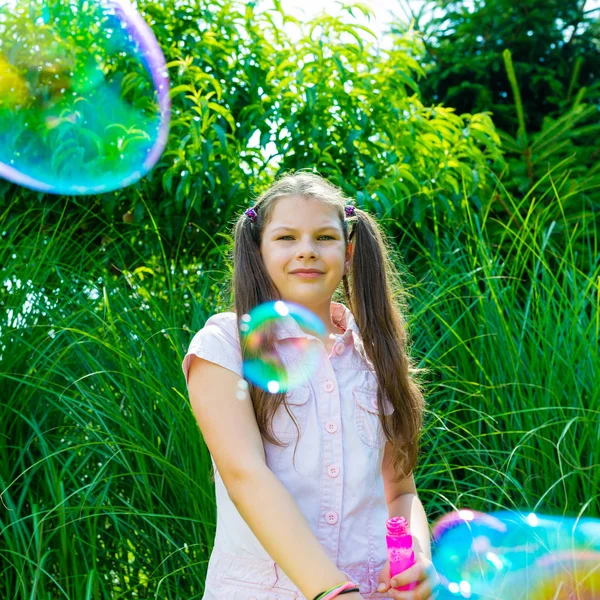Enfant fille jouer avec savon baguette à bulles dans le parc — Photo