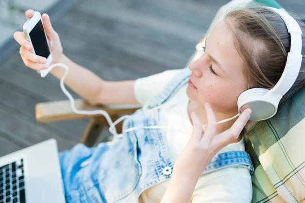 Primo piano di bella ragazza adolescente in cuffia ascoltare musica — Foto Stock