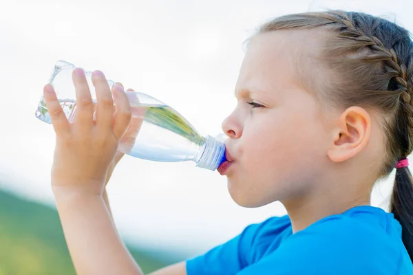 Маленькая девочка пьет свежую воду из бутылки — стоковое фото