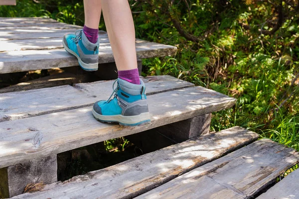 Wanderin mit Stiefeln auf Holzpfad, Aktivität im Freien — Stockfoto