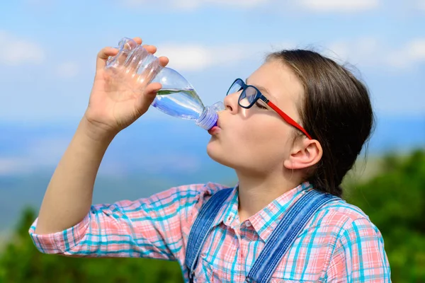 Молодая девушка пьет воду на открытом воздухе — стоковое фото