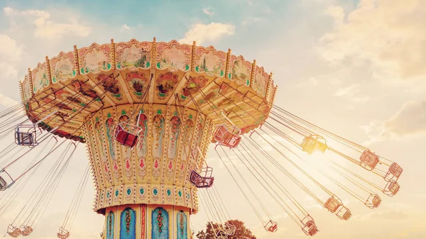 Carousel ride spins fast in the air at sunset - vintage filter effects — Stock Photo, Image