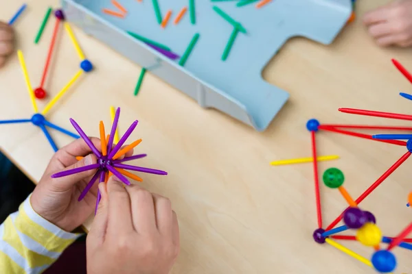 Två små flickor leker med massor av färgglada plast pinnar ki — Stockfoto