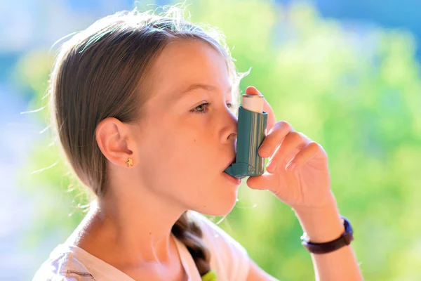 Chica que usa inhalador de asma en un parque — Foto de Stock