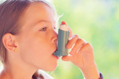 Astım inhaler bir parkta kullanan kız