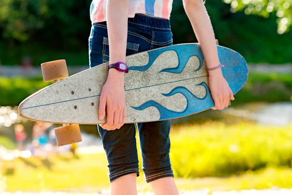 Ung skateboard flicka håller hennes longboard utomhus på sunset — Stockfoto