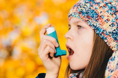 Astım inhaler bir parkta kullanan kız