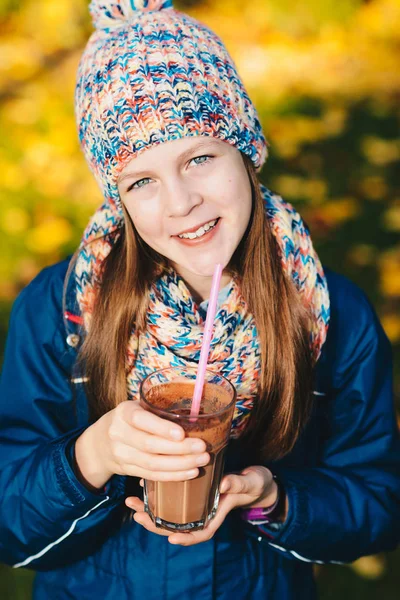 秋の公園でチョコレート、ミルクセーキの飲み物を飲む少女 — ストック写真