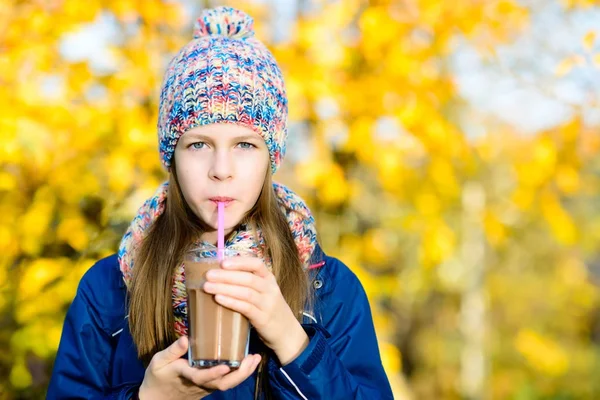 秋の公園でチョコレート、ミルクセーキの飲み物を飲む少女 — ストック写真
